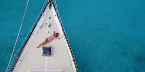 Eine Frau genehmigt sich ein Sonnenbad auf Deck